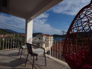 een balkon met 2 stoelen en uitzicht op het water bij Iris Apartments Ithaca in Vathi