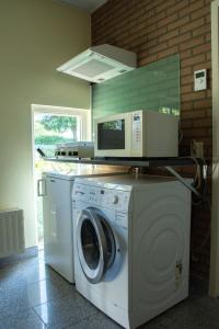 a washing machine with a microwave on top of it at Bed and Breakfast Lindershoeve Bergeijk in Bergeijk