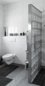 a white bathroom with a toilet and a shower at Bed and Breakfast Lindershoeve Bergeijk in Bergeijk