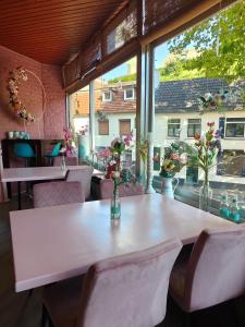 un tavolo bianco con sedie in una stanza con finestra di Hotel B&B LeLa a Valkenburg