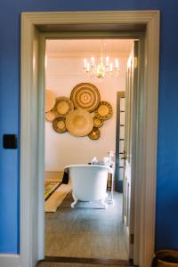 a bathroom with a white tub and plates on the wall at La Fontaine Boutique Hotel by The Oyster Collection in Franschhoek