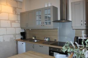 a kitchen with white cabinets and a sink at Gîte Moulin d'Olivet in Chartrené