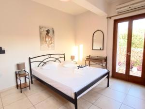 um quarto com uma cama, uma mesa e uma janela em Iris Apartments Ithaca em Vathi