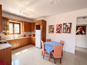 a kitchen with a table and a white refrigerator at Iris Apartments Ithaca in Vathi