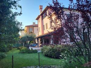 una casa con una recinzione di fronte a un cortile di Casa Elti - Shanti and Jay apartments a Lido di Venezia