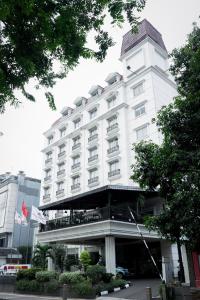 a large white hotel building with a balcony at Arion Suites Hotel Kemang in Jakarta