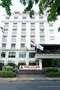 a white building with two flags in front of it at Arion Suites Hotel Kemang in Jakarta