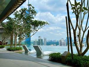 a row of white chairs sitting next to the water at Maxhome at Axon Bukit Bintang in Kuala Lumpur