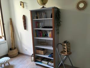 une étagère remplie de livres dans une pièce dans l'établissement Entre Voyages et Occitanie, à Vers-Pont-du-Gard