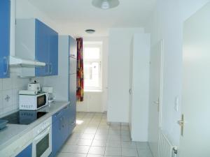 a kitchen with blue cabinets and a microwave at Apartment Messe in Vienna