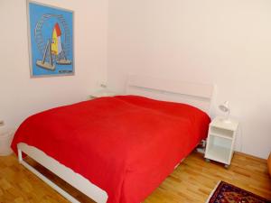 a bedroom with a red blanket on a bed at Apartment Messe in Vienna