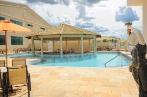 a man standing next to a pool at a hotel at Lacqua Di Roma Caldas Novas in Caldas Novas