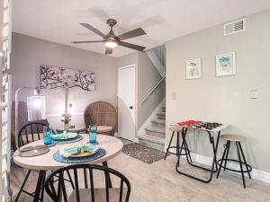 ein Wohnzimmer mit einem Tisch, Stühlen und einer Treppe in der Unterkunft Stunning Tree Tops Apt - Disney! in Kissimmee