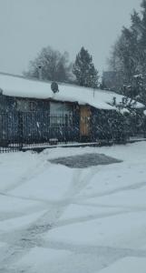a fence covered in snow next to a driveway at CASA VISTA CORRAL in Malalcahuello