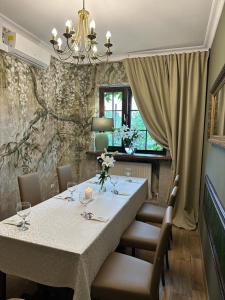 une salle à manger avec une table, des chaises et un lustre dans l'établissement Hotel Kresowianka, à Konin