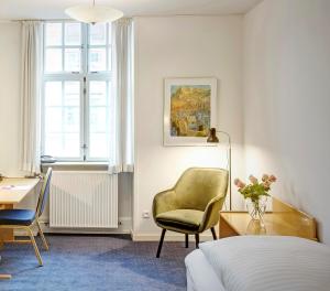 a bedroom with a bed and a chair and a desk at Palads Hotel in Viborg