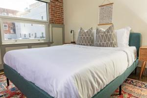 a bedroom with a large bed and a window at Luxury 2 Br Apartment With Modern Accents Downtown in Roanoke