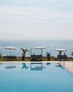a swimming pool with a view of the ocean at Hotel Santa Marta in Lloret de Mar