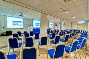 a conference room with blue chairs and a screen at Hotel Dei Principati in Baronissi