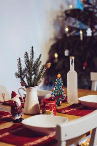 a table with a christmas tree and a vase on it at Chalúpka na konci in Banská Štiavnica