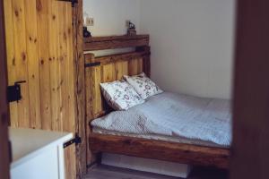 a bedroom with a bed in a room with wooden walls at Chalúpka na konci in Banská Štiavnica +27 photos