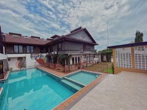 a large swimming pool in front of a house at Urban Glamp Resort in Oton