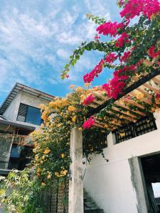 a bunch of flowers hanging from a building at Urban Glamp Resort in Oton