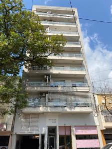 a tall white building with a balcony in front of it at Departamento Arbo y Blanco in Resistencia