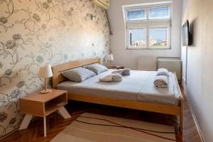 a small bedroom with a bed and a window at Apartman Centar in Niš