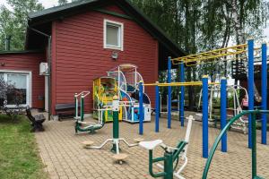 a playground in front of a red house at Senelio Romo Sodyba in Molėtai