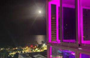 widok na ocean w nocy z fioletowymi światłami w obiekcie Alicante Apartamento en la Playa Muchavista-San Juan - Marluma frente al Mar w mieście La Venteta