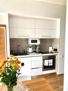uma cozinha com armários brancos e um forno com placa de fogão em Apartment Dzelzavas 19/3 em Riga