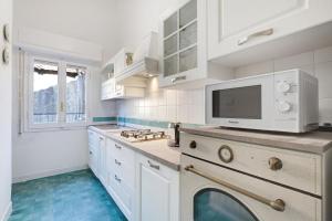 uma cozinha com armários brancos e uma máquina de lavar louça em Pratolina em Savona