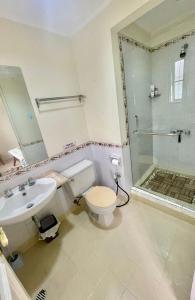 a bathroom with a toilet and a sink and a shower at Flower House Villa in Bogor