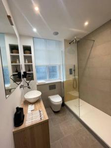 a bathroom with a sink and a toilet and a shower at Stylish city-centre apartment with balcony in Liverpool