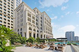 an exterior rendering of a hotel with tables and chairs at Vida Creek Beach Hotel in Dubai