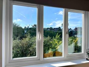 - deux fenêtres dans une chambre avec vue sur les arbres dans l'établissement Large 5 bed detached house near Stansted Airport, à Stansted Mountfitchet