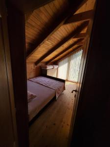 a small room with a bed in a wooden house at Vikendica Brvnara Marčetić in Banja Luka