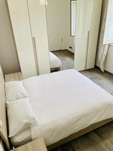 a bedroom with a white bed and a mirror at CASA CON GIARDINO NETFLIX E SERVIZIO RISTORAZIONE - 10 minuti da Torino in Volvera