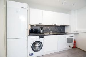 cocina blanca con lavadora y fregadero en Casa Amare Tampere, en Tampere