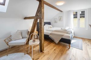 ein Schlafzimmer mit einem Bett und einem Stuhl darin in der Unterkunft habu bei OLMA cosy stay in St. Gallen