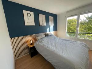 1 dormitorio con cama y pared azul en Disney appartement en Chessy