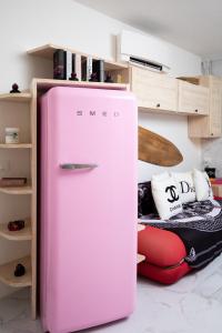 a pink refrigerator is sitting in a room at Casa Eva Luna by Wonderful Italy in Olbia