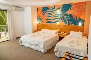 duas camas num quarto com um quadro na parede em Los Lagos Resort Hotel em Capiatá