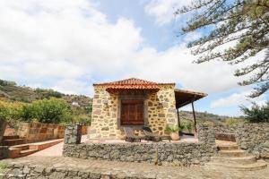 een klein huis met een stenen muur bij Countryside Views House Teror in Teror
