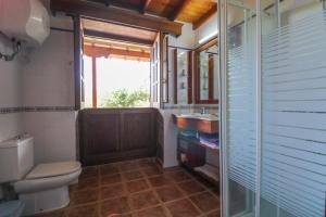 a bathroom with a toilet and a sink and a window at Countryside Views House Teror in Teror