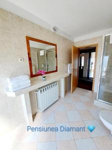 y baño con lavabo y espejo. en Pensiunea Diamant, en Ghimbav