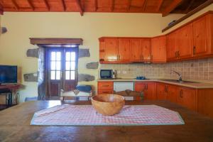 een keuken met houten kasten en een houten kom op een tafel bij Countryside Views House Teror in Teror +54 foto's