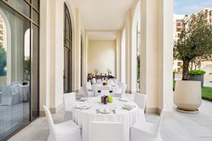 a restaurant with white tables and white chairs at Vida Creek Beach Hotel in Dubai