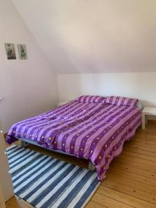 - un lit avec une couette violette dans une chambre dans l'établissement Fewo Urlaubsspaß, à Kalyves